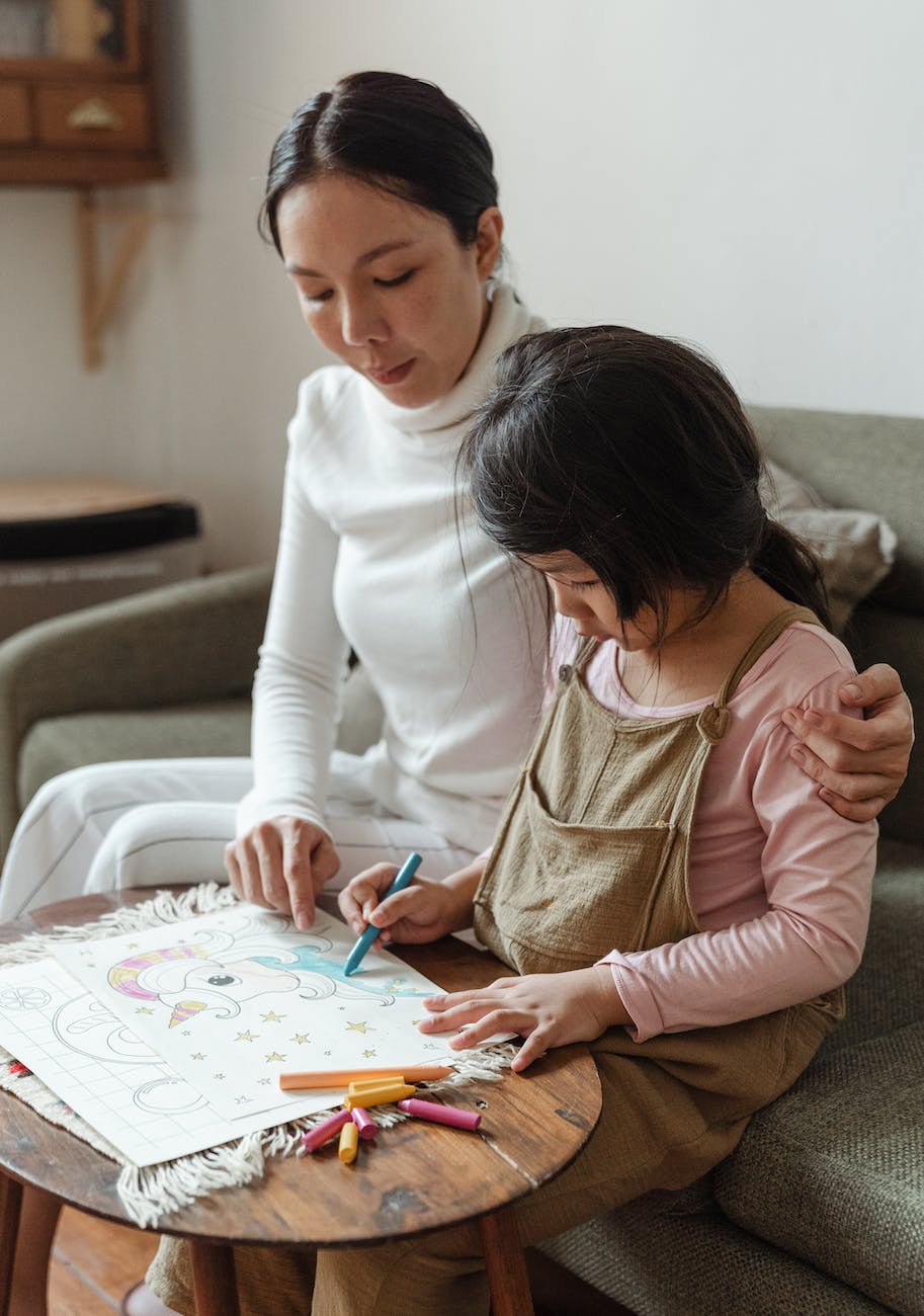 focused mother and daughter drawing on paper