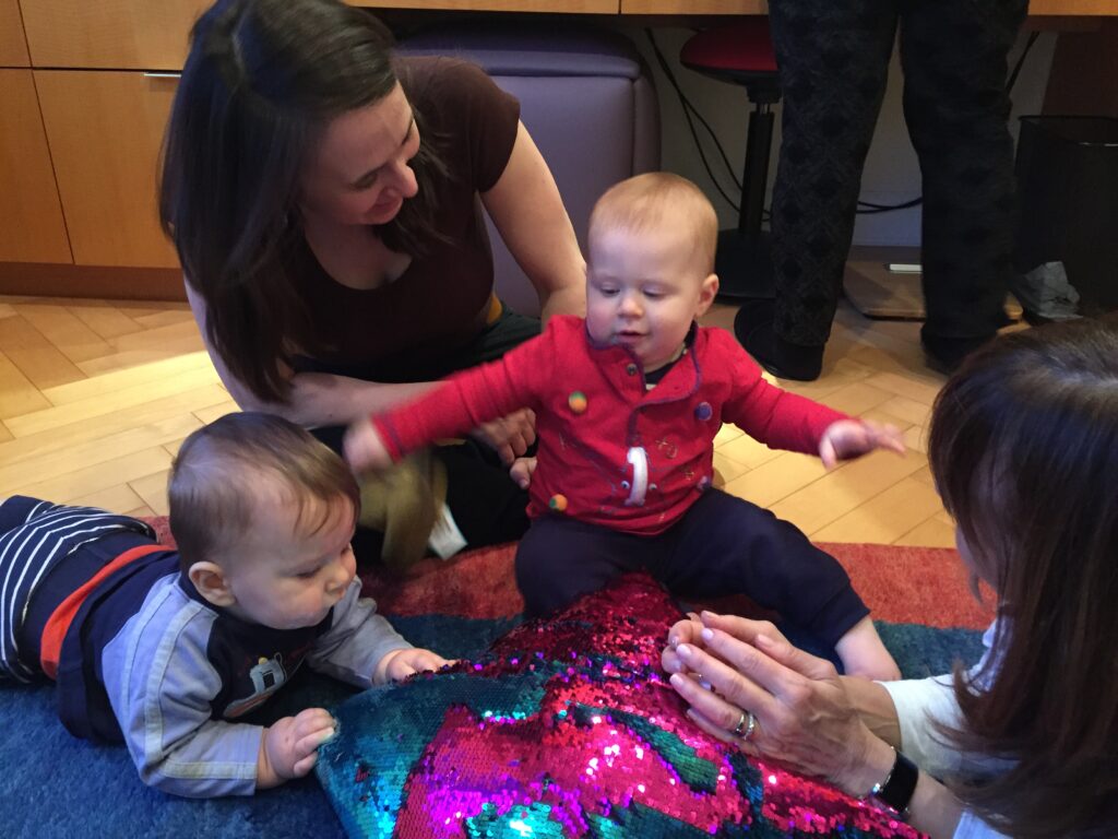 Lisa on the floor working with two babies